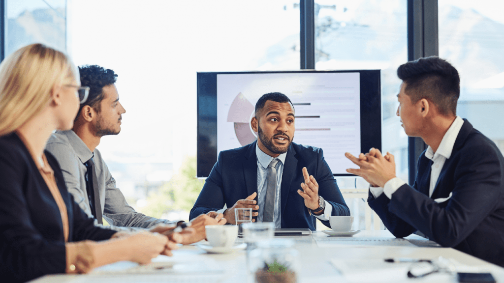 Employer presenting health insurance benefits to a team during a boardroom meeting, illustrating a complete guide to understanding health insurance for individuals and employers