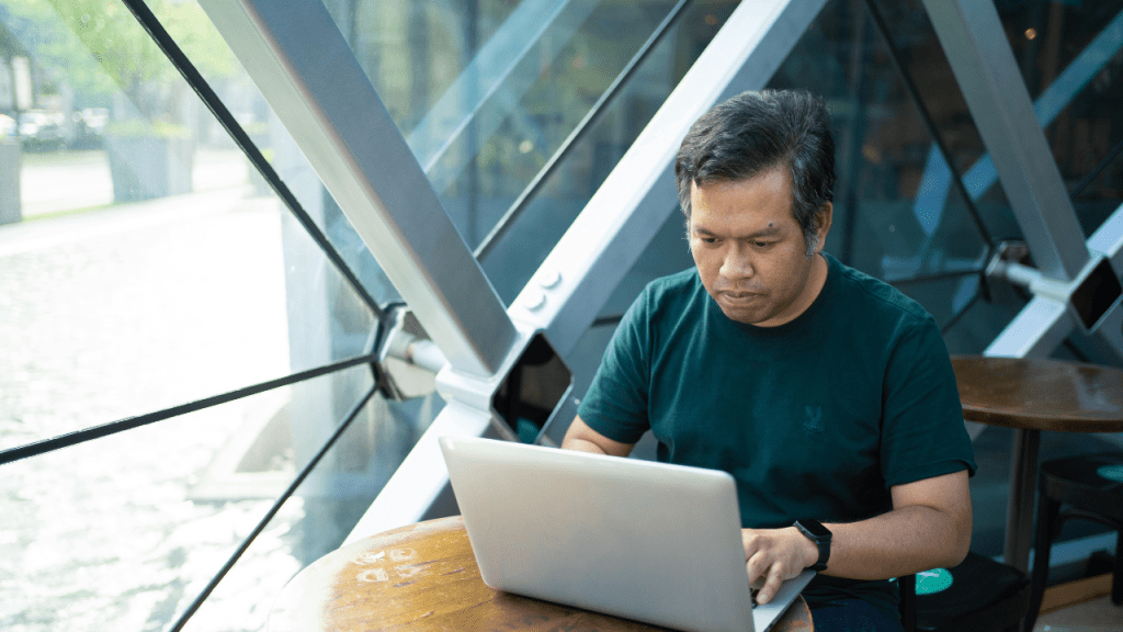 A 1099 independent contractor reviewing COBRA insurance costs on a laptop with a concerned expression, illustrating a guide to COBRA alternatives and coverage gaps