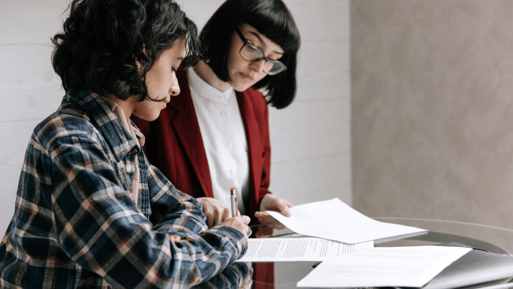 A self-employed woman reviewing health insurance paperwork with an advisor, illustrating affordable health coverage options for 1099 and independent workers